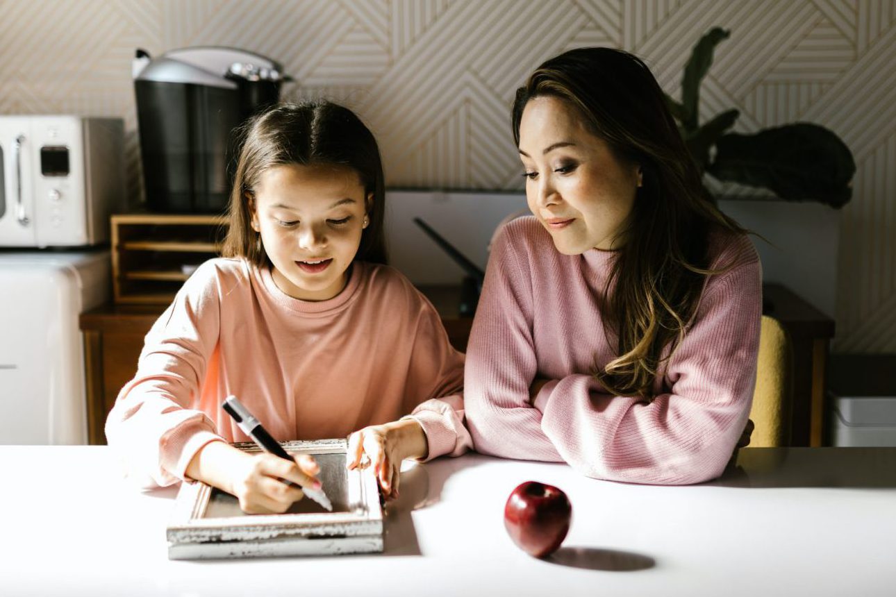 Mom and daughter sit at the table to set goals